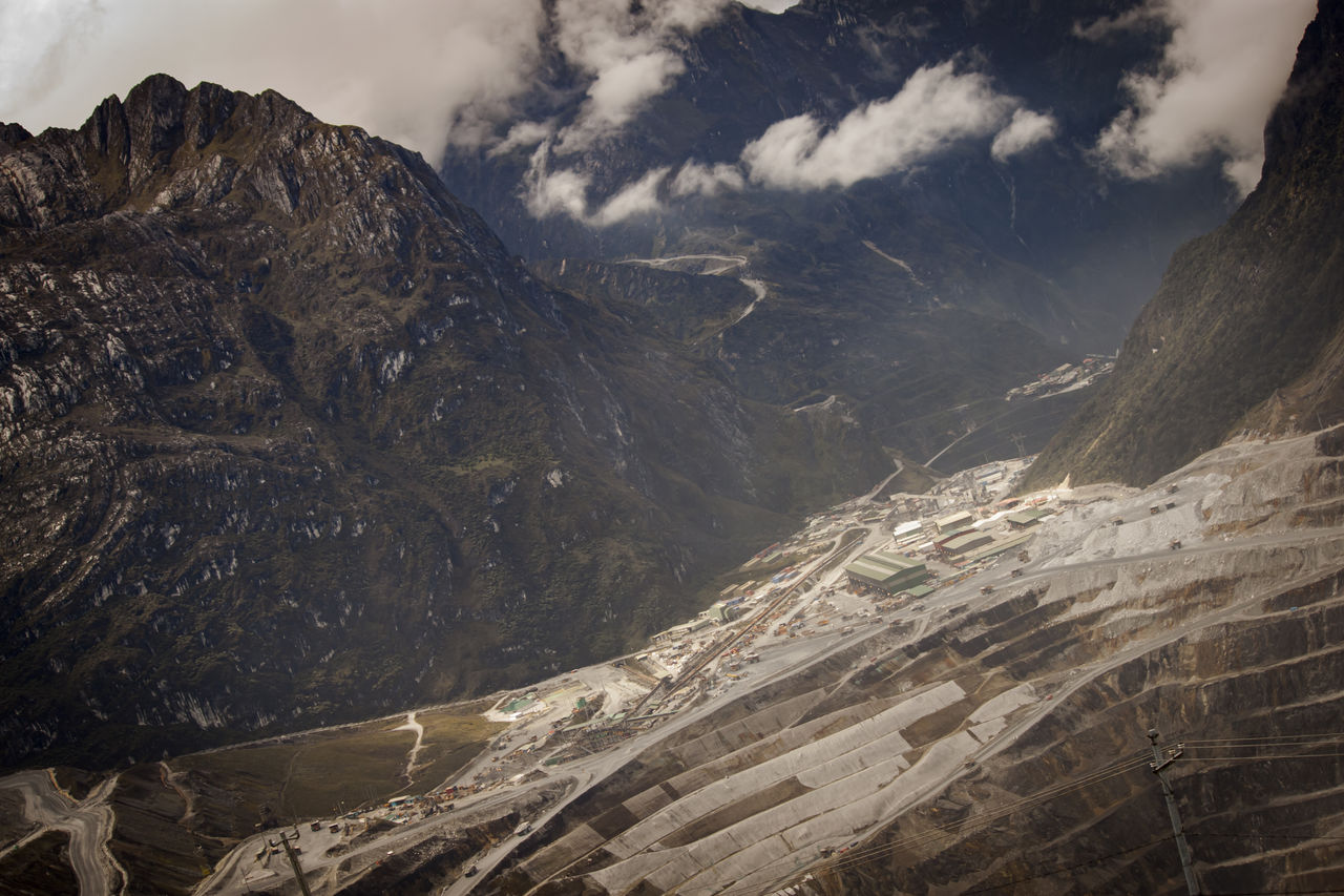 Aerial view of mountain range and open pit grasberg mine against sky