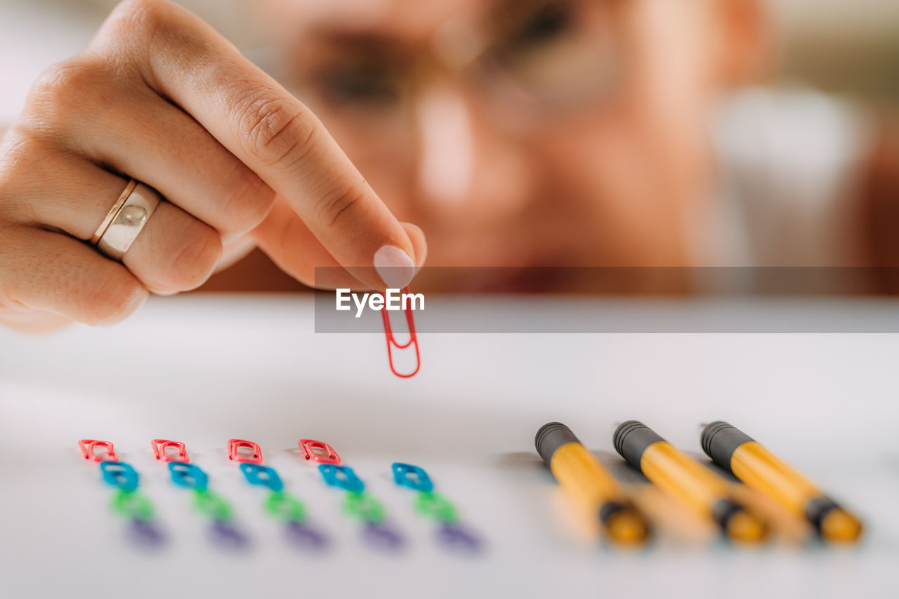 Woman with ocd. obsessive compulsive disorder concept. placing paperclips in a straight line.