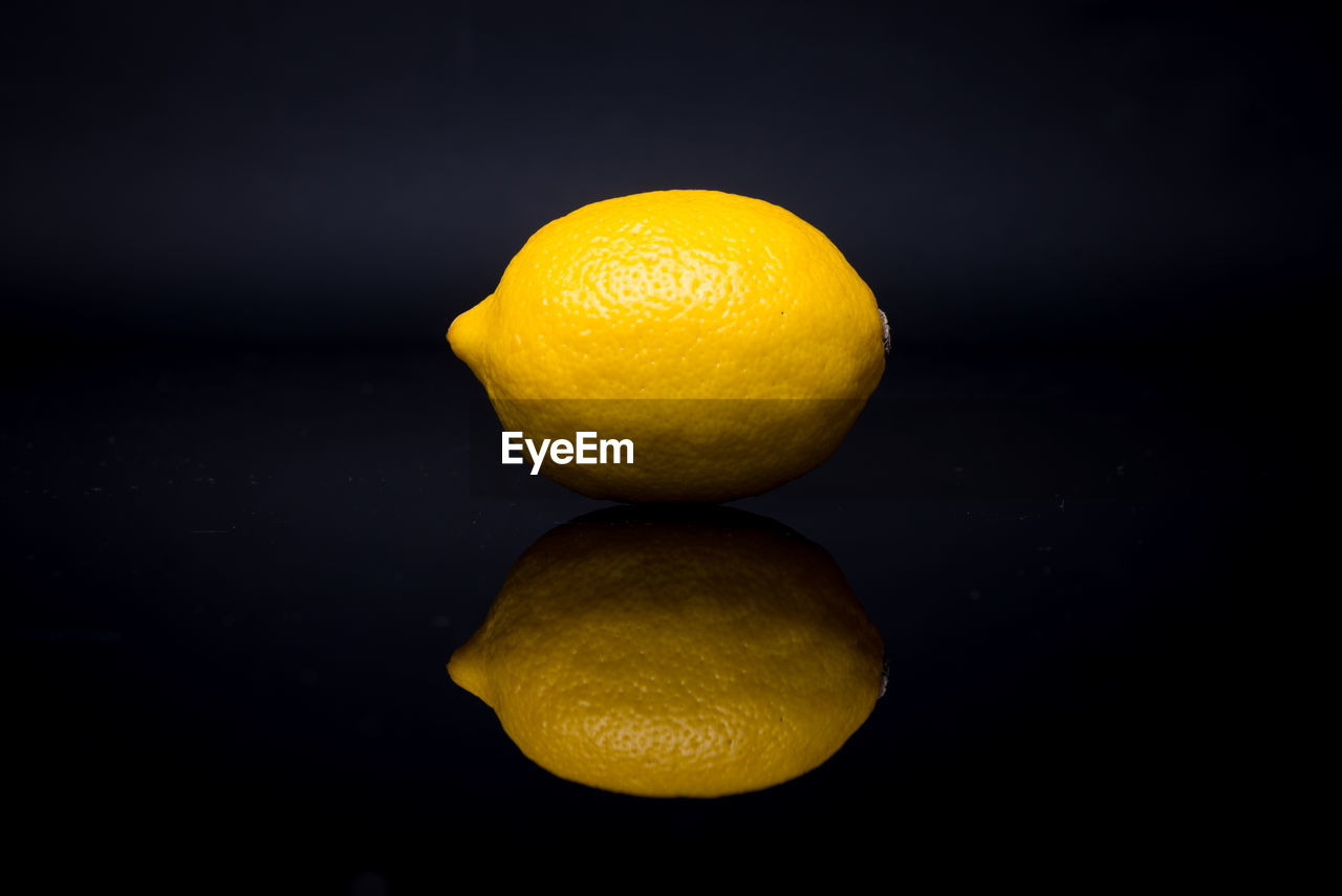 One lemon against black background