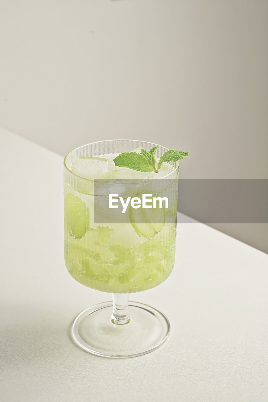 GREEN DRINK WITH GLASS OF WHITE BACKGROUND