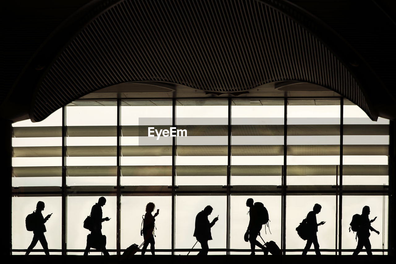 Silhouette people walking at airport