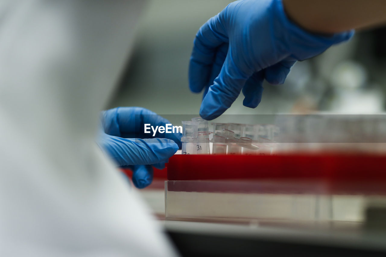 Midsection of scientist examining chemicals at laboratory