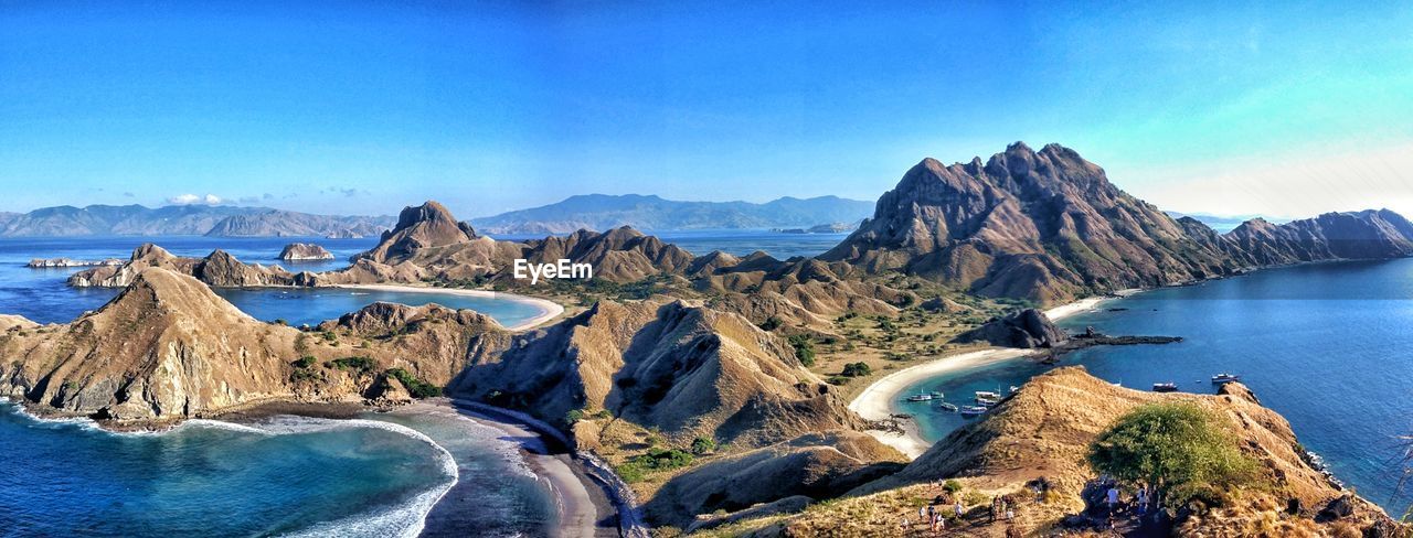 Panoramic view of rocks in sea against clear blue sky