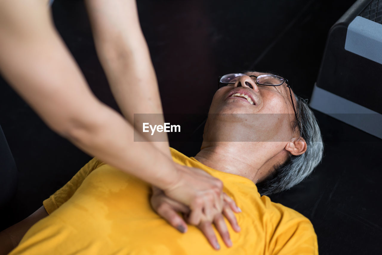 Cpr to heart attack shock man after workout in gym 
