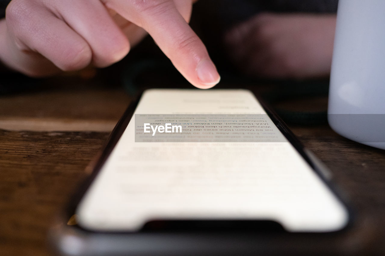 CLOSE-UP OF PERSON USING LAPTOP ON TABLE