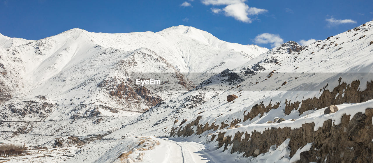 PANORAMIC VIEW OF SNOWCAPPED MOUNTAIN AGAINST SKY