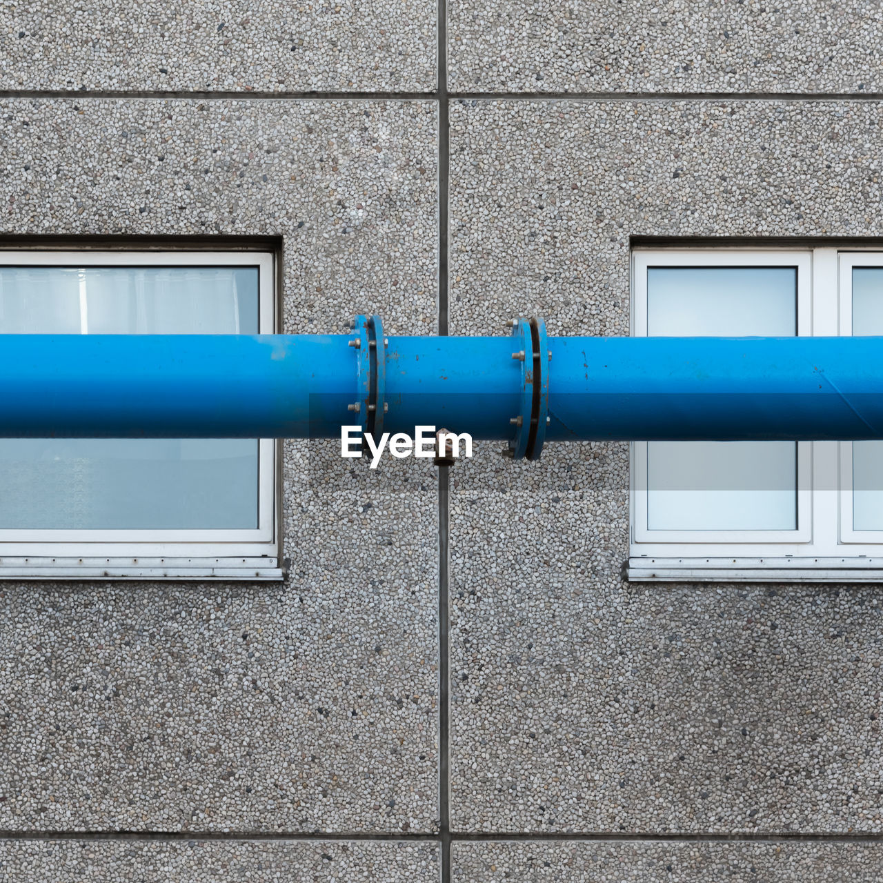 The blue water pipe in front of the windows of the prefabricated house
