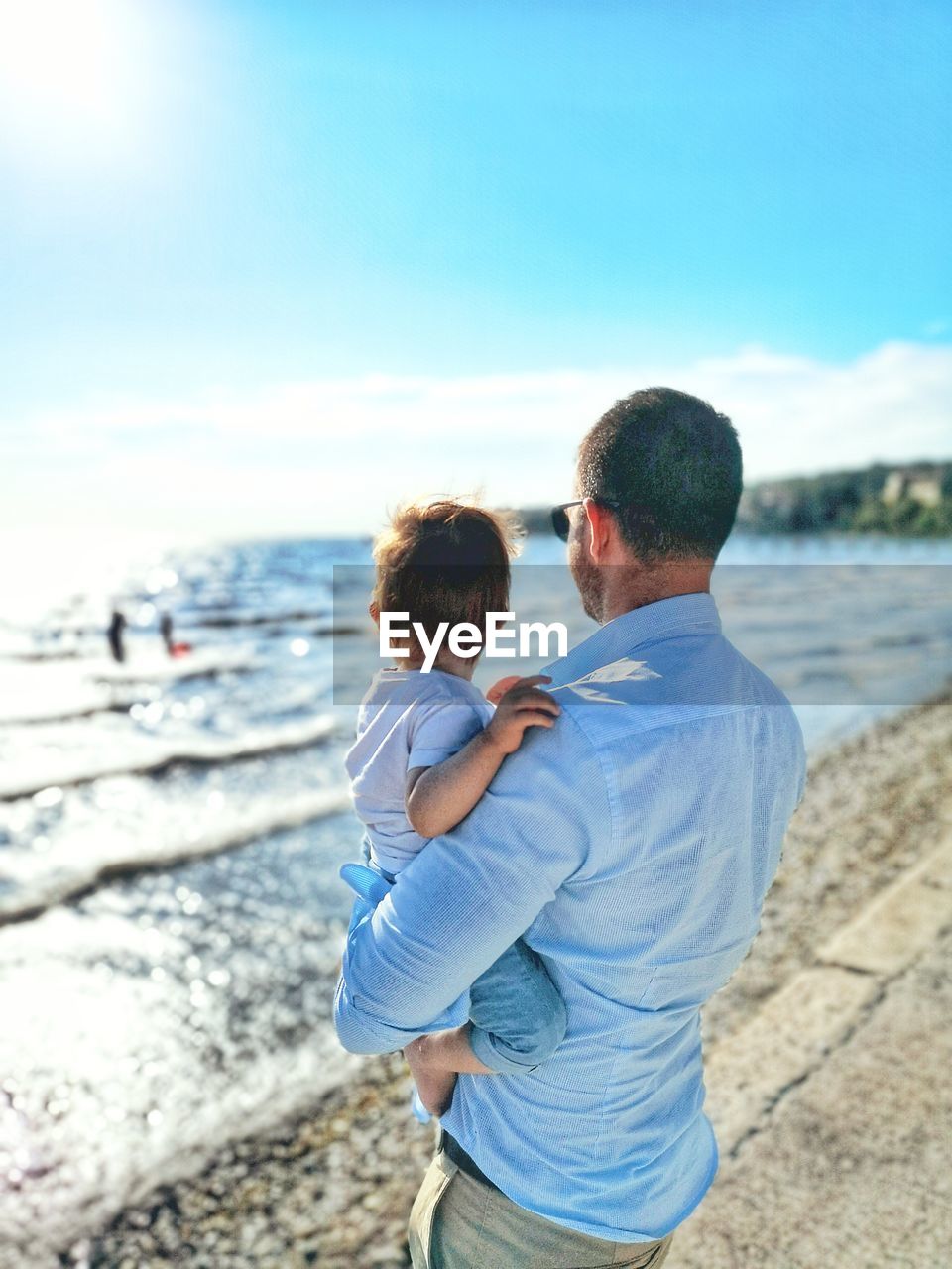 Rear view of couple at beach against sky