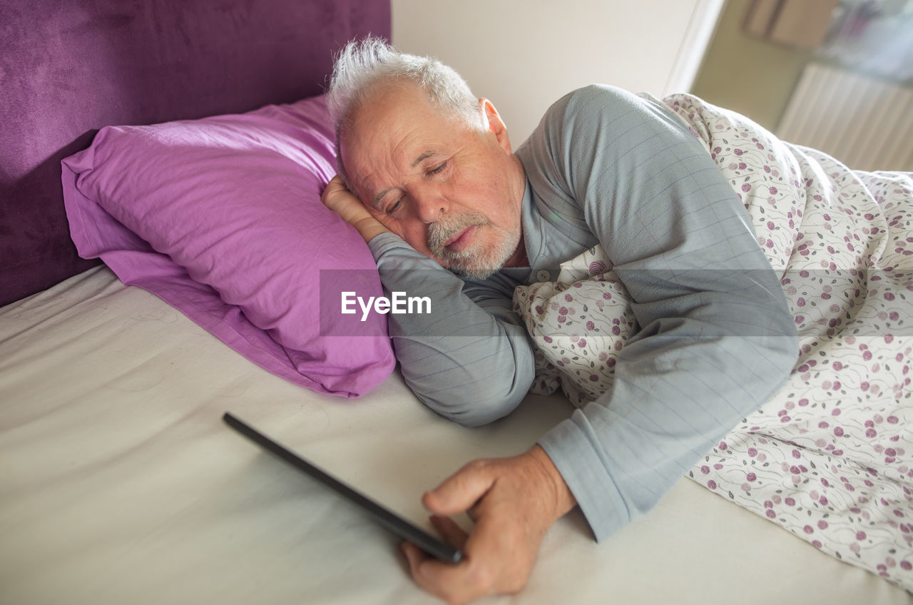MAN LYING ON BED AT HOME