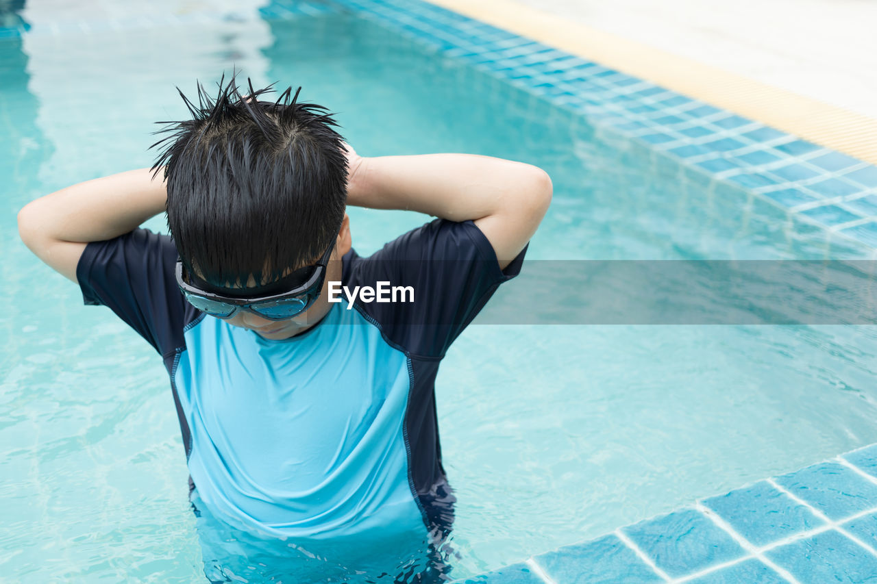 Close-up shot of a boy putting on swim goggles.boys preparing for swimming lessons in the pool