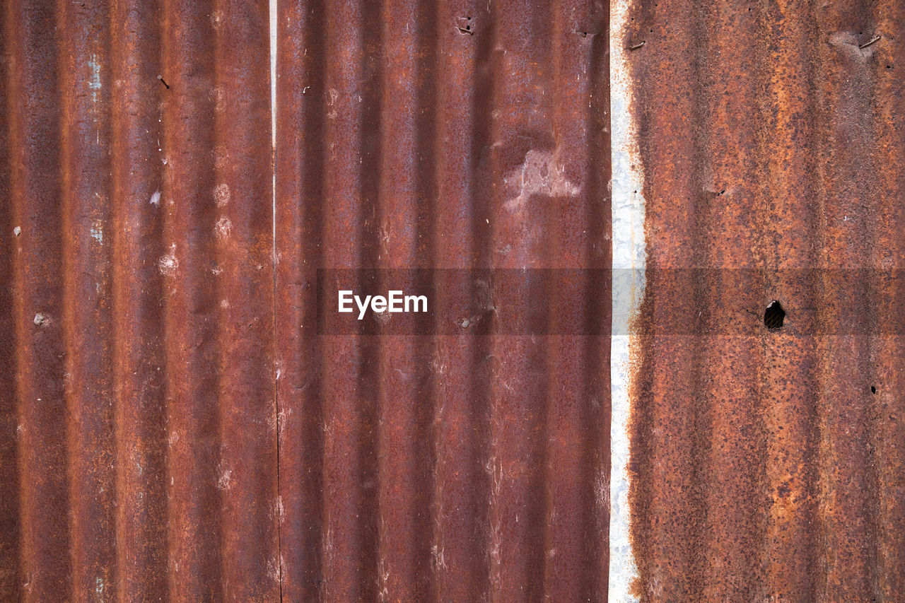 FULL FRAME SHOT OF RUSTY METALLIC STRUCTURE IN CONTAINER