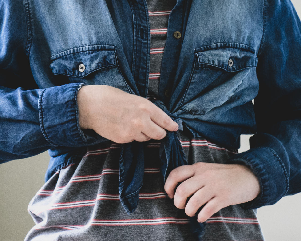 Midsection of woman wearing denim jacket