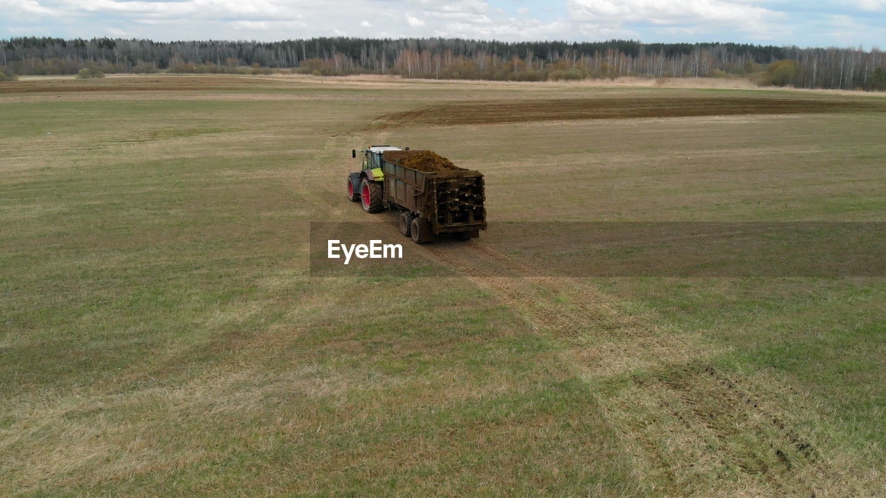 TRACTOR ON FIELD BY LAND