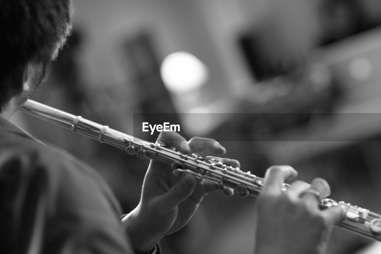 Close-up of man playing flute
