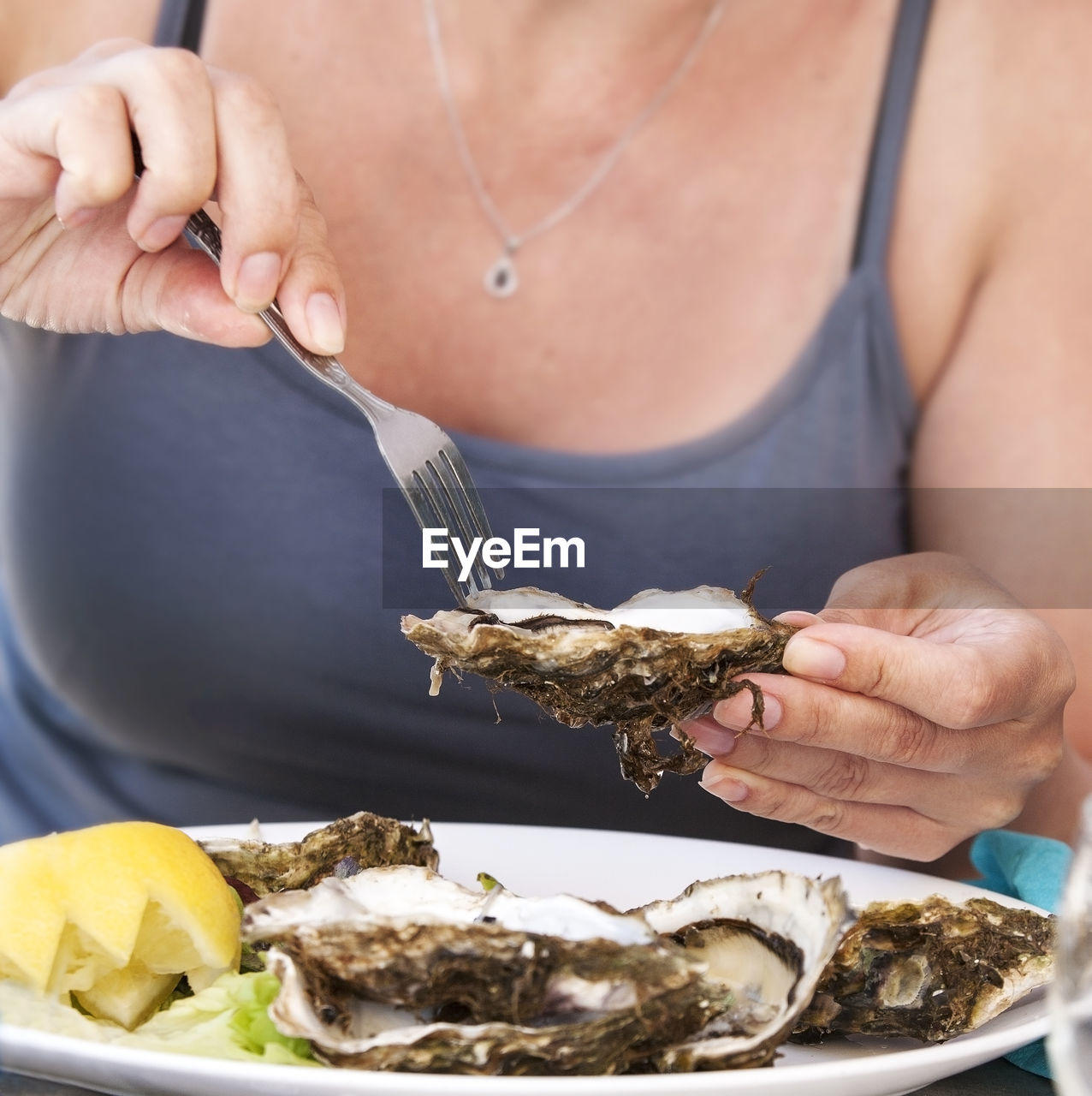Woman eat with a fork oysters