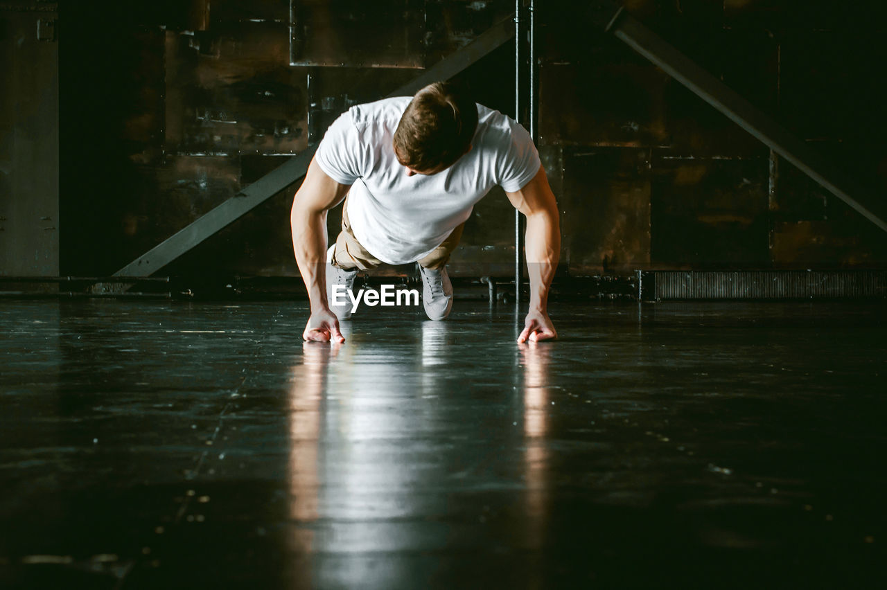Muscular man doing push-ups at home