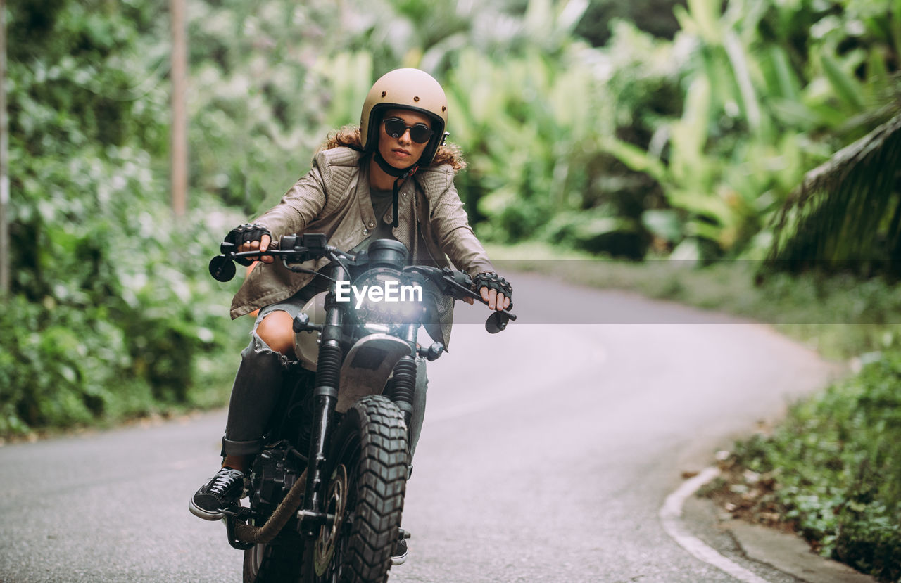 Portrait of woman riding motorcycle on road