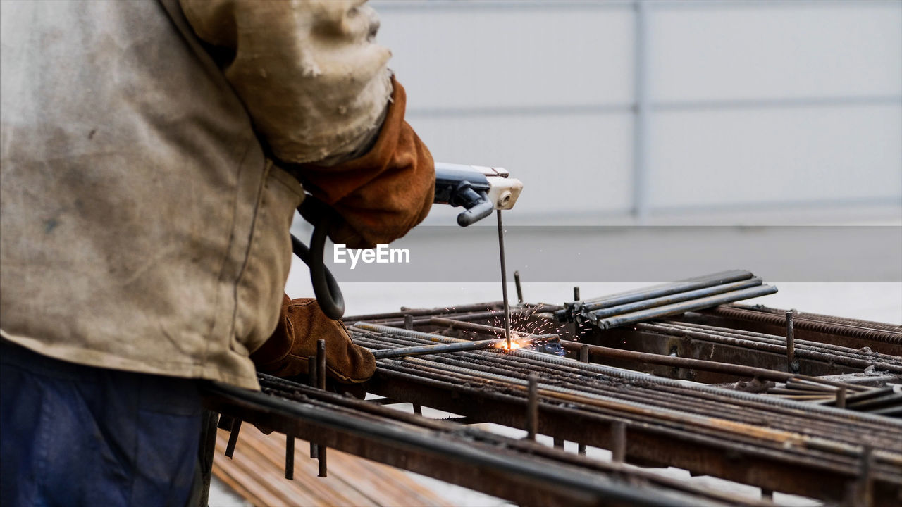 Man working on metal structure in factory