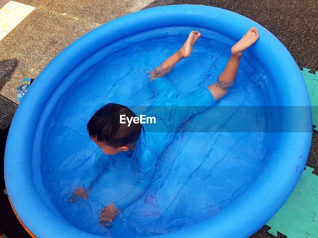 High angle view of boy swimming in wading pool