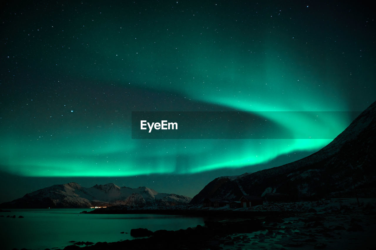 Scenic view of snowcapped mountains and aurora borealis against sky at night