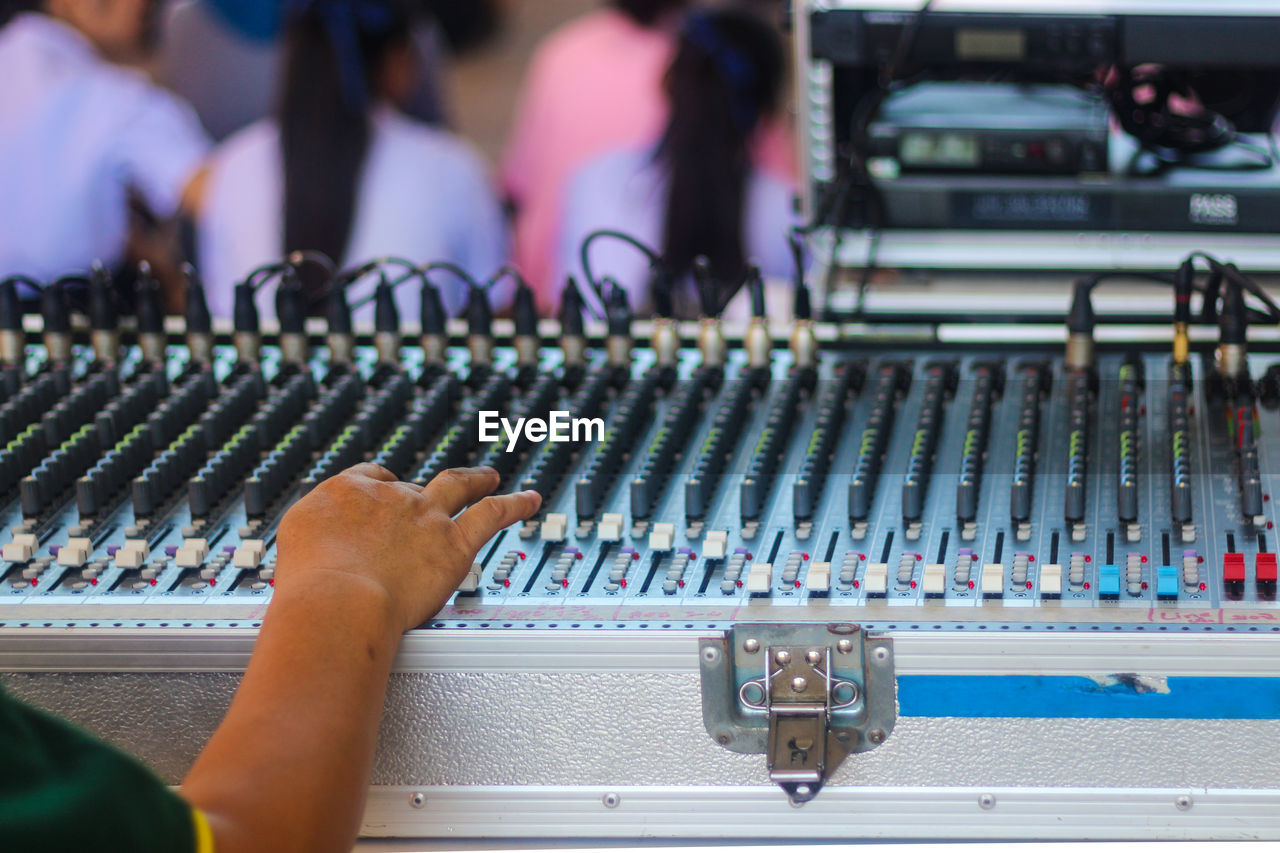 Close-up of musician hand adjusting audio equipment