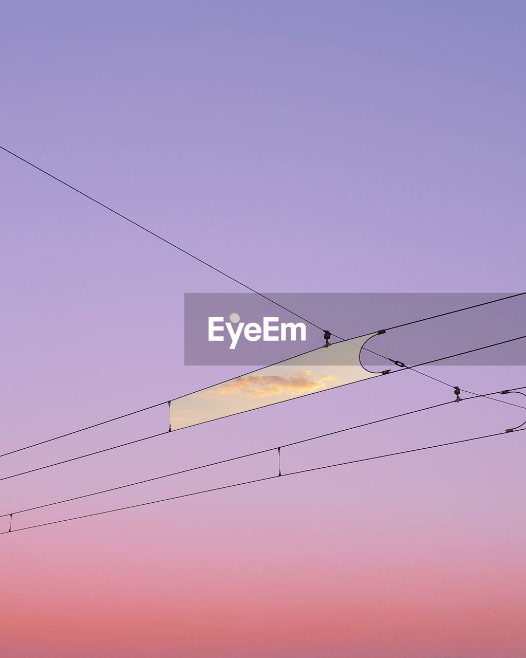 Digital composite image of clouds amidst cables against sky during sunset