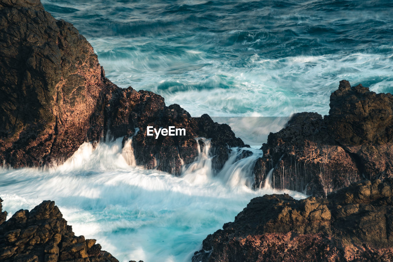 water, sea, rock, beauty in nature, motion, coast, scenics - nature, land, wave, ocean, nature, beach, water sports, surfing, sports, wind wave, body of water, cliff, rock formation, shore, environment, terrain, power in nature, outdoors, splashing, travel destinations, long exposure, landscape, idyllic, coastline