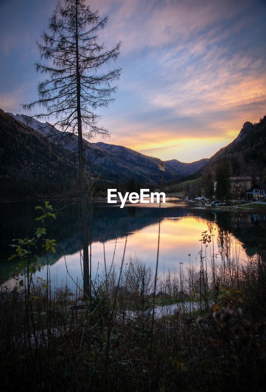 SCENIC VIEW OF LAKE BY SILHOUETTE MOUNTAINS AGAINST SKY