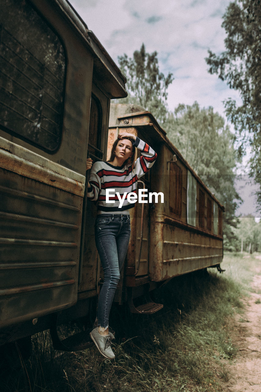 Woman standing in rusty train