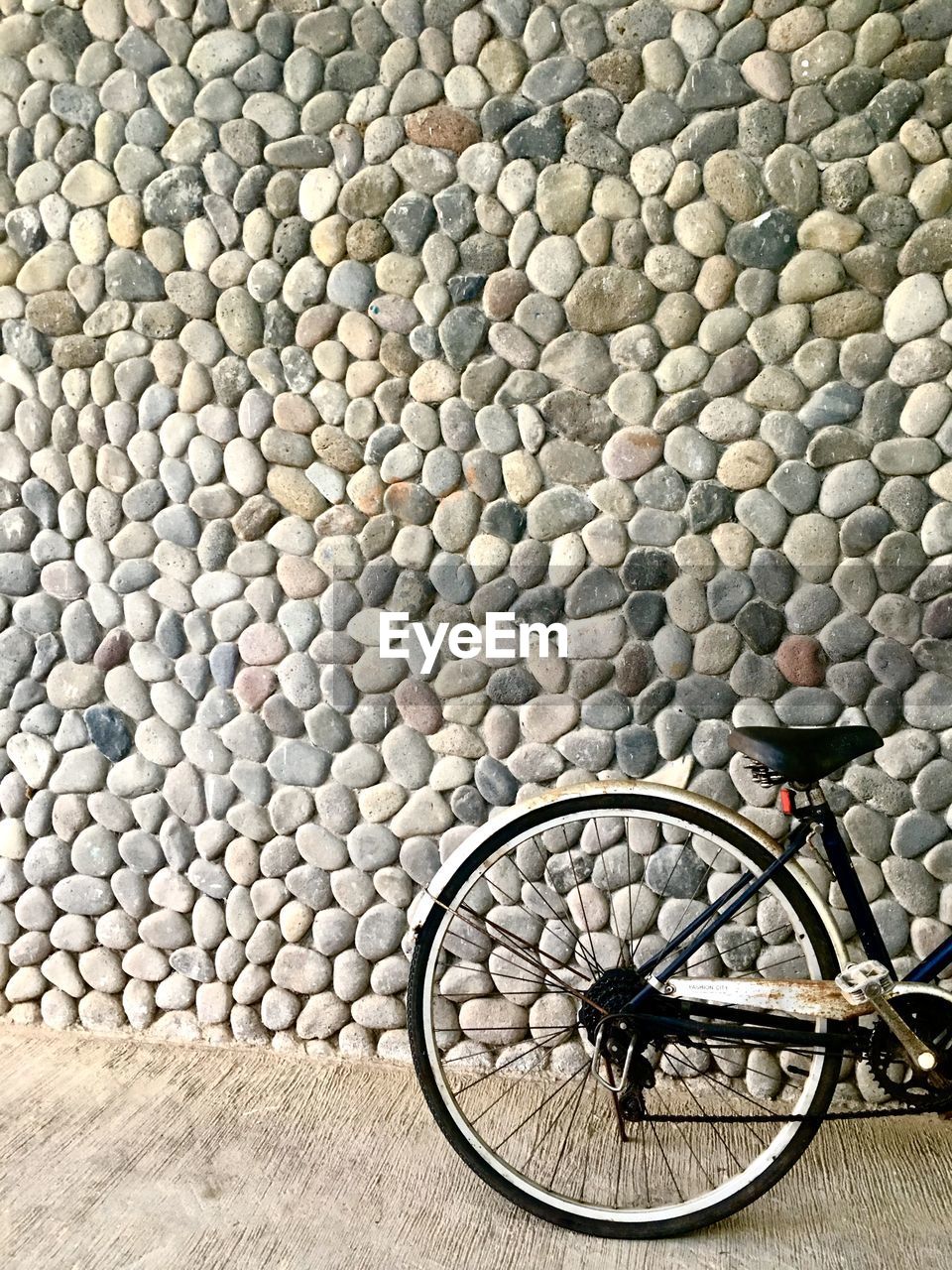 High angle view of bicycle parked by stone wall