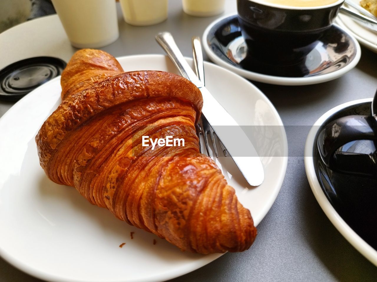 food and drink, croissant, food, drink, cup, meal, dish, mug, plate, french food, breakfast, dessert, coffee, coffee cup, baked, table, viennoiserie, refreshment, pastry, freshness, no people, bread, cuisine, high angle view, indoors, fast food, crockery, hot drink, eating utensil, sweet food, close-up, kitchen utensil, still life, baked pastry item