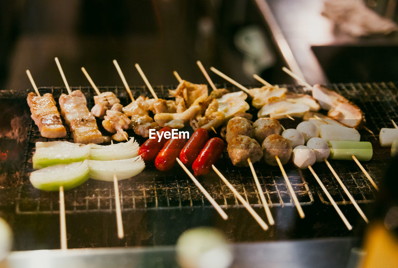 Close-up of yakitori skewers being grilled over charcoal
