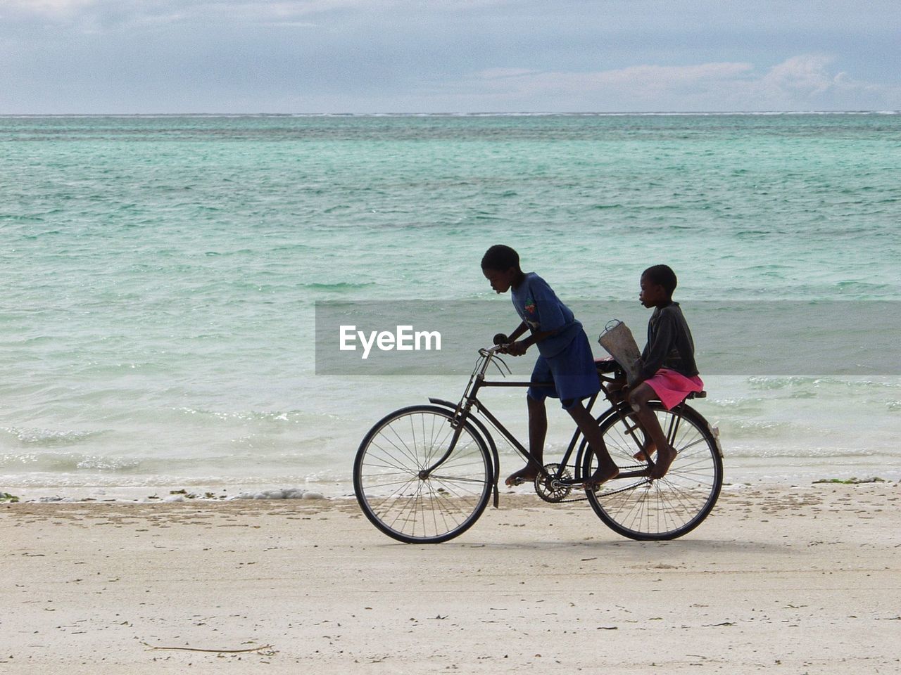 MAN AND BICYCLE ON BEACH