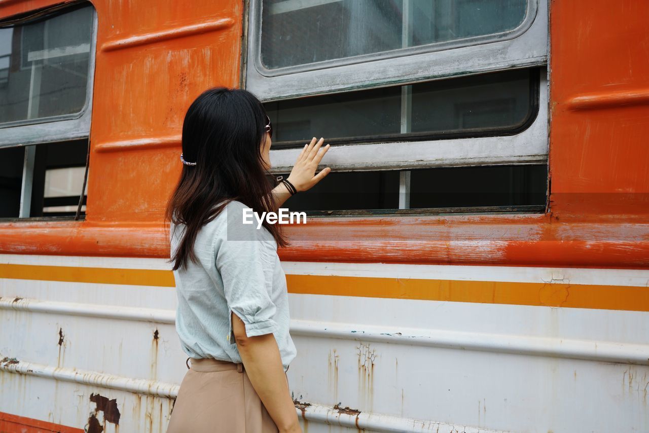 Side view of woman standing by train at station
