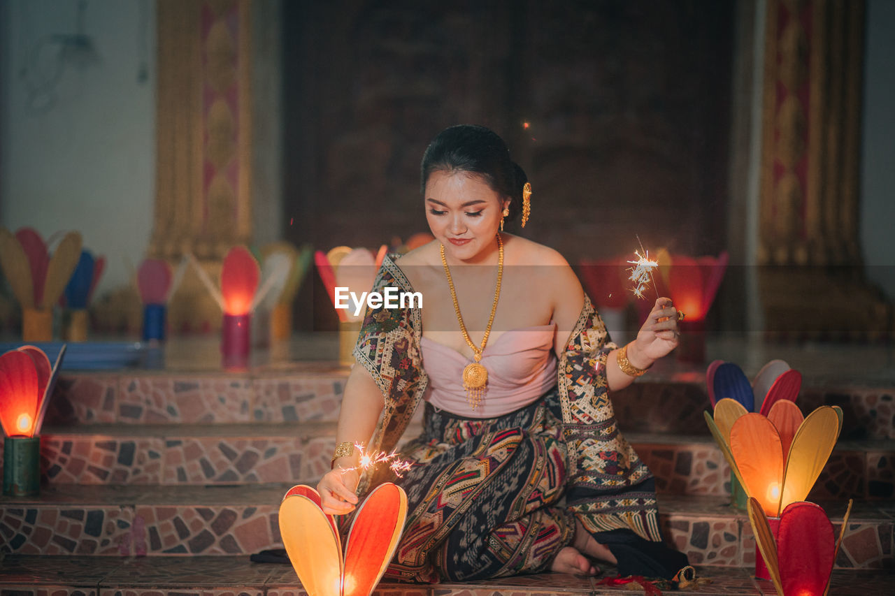 portrait of young woman holding sparkler