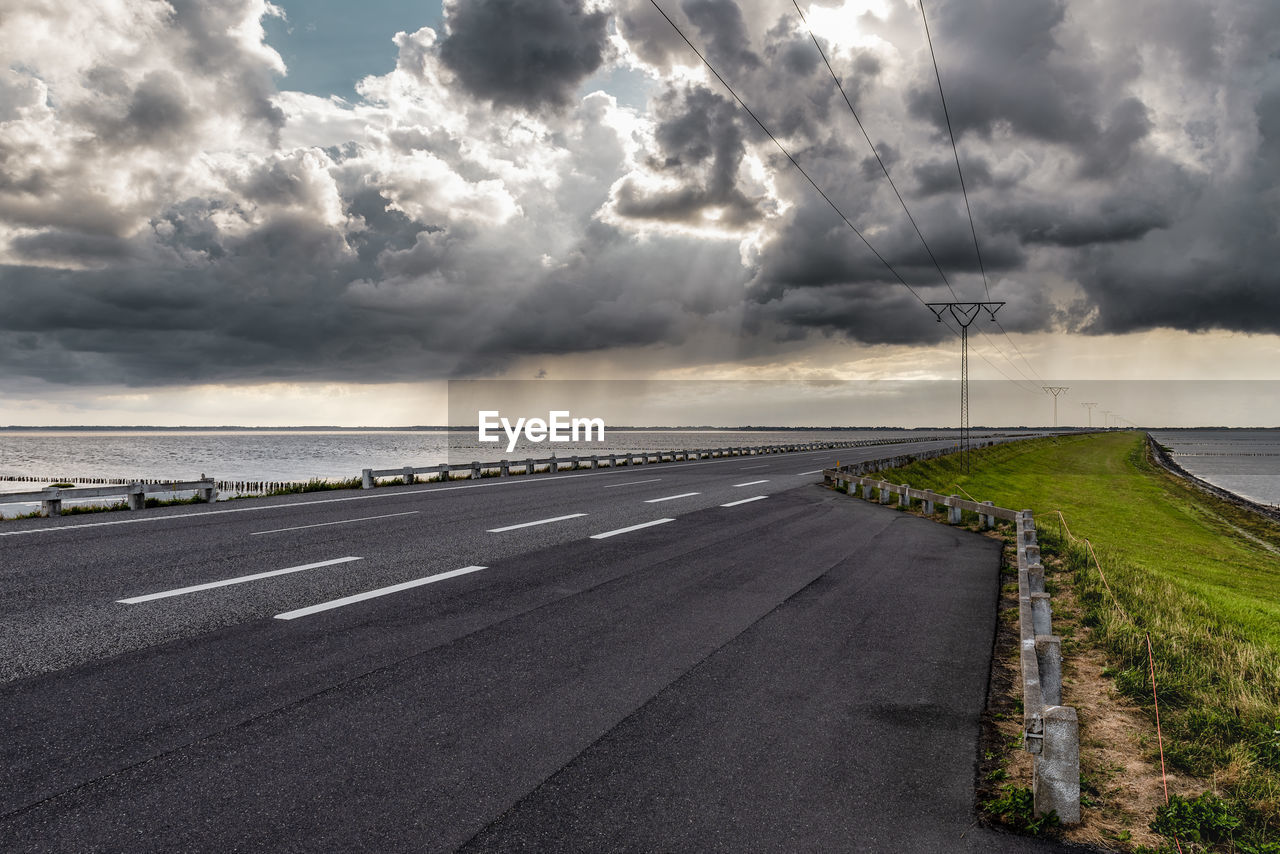 ROAD BY SEA AGAINST CLOUDY SKY