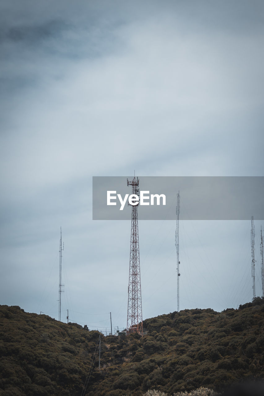 technology, sky, tower, communications tower, communication, broadcasting, cloud, telecommunications equipment, nature, global communications, built structure, no people, architecture, wireless technology, environment, land, wind, satellite dish, electricity, mountain, antenna, power generation, landscape, satellite, transmission tower, electricity pylon, outdoors, cable, low angle view, horizon, day, scenics - nature, non-urban scene, power supply, overhead power line, industry, copy space, telecommunications engineering, beauty in nature, sea, overcast, radio