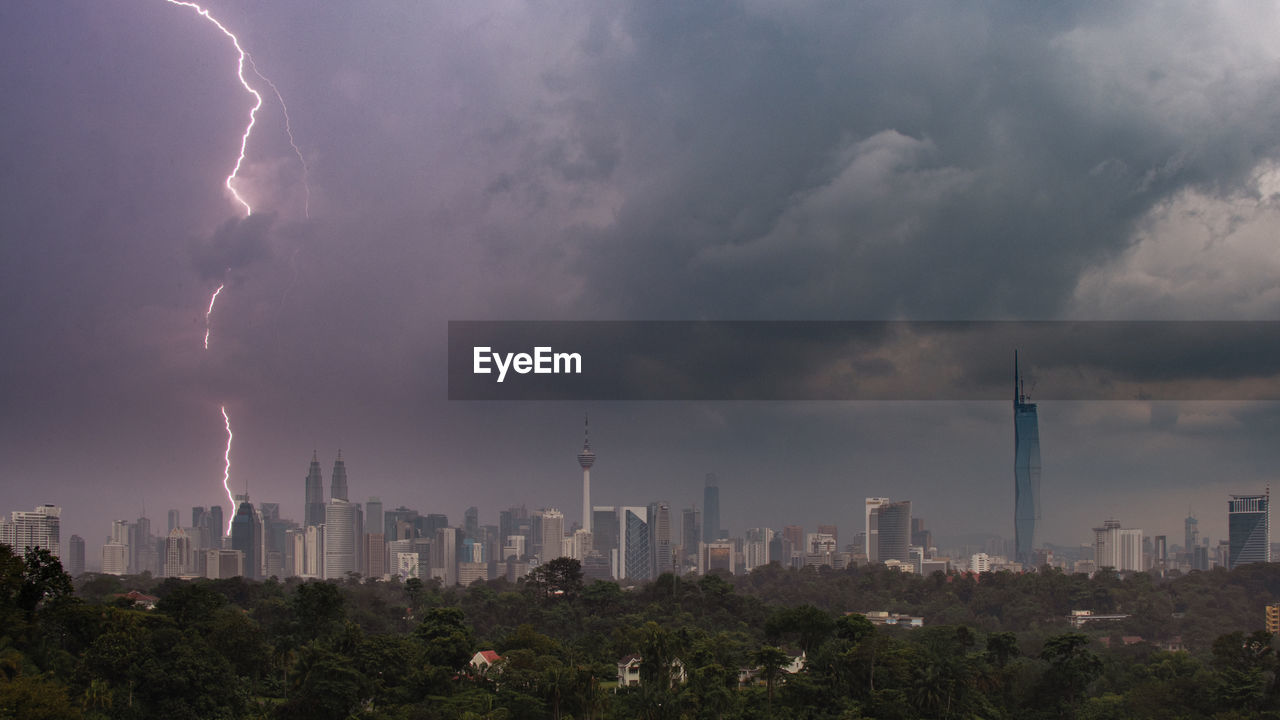 cloud, storm, city, sky, building exterior, architecture, landscape, built structure, thunderstorm, power in nature, lightning, cityscape, building, environment, office building exterior, urban skyline, skyscraper, storm cloud, nature, thunder, dramatic sky, beauty in nature, skyline, outdoors, panoramic, city life, night, overcast, residential district, no people, communication, rain, travel destinations, warning sign, sign, extreme weather, wet, dark, tower, cloudscape