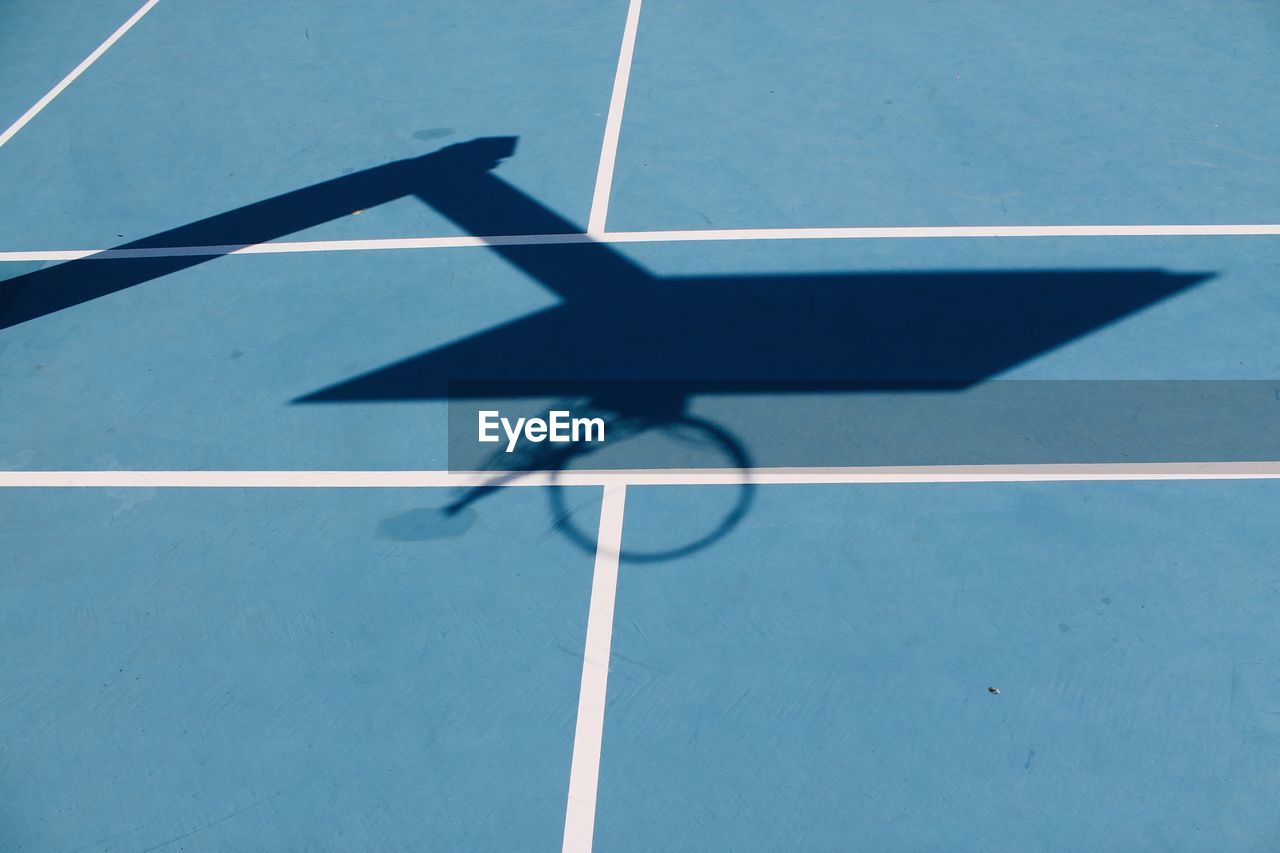 High angle view of basketball hoop shadow on blue court