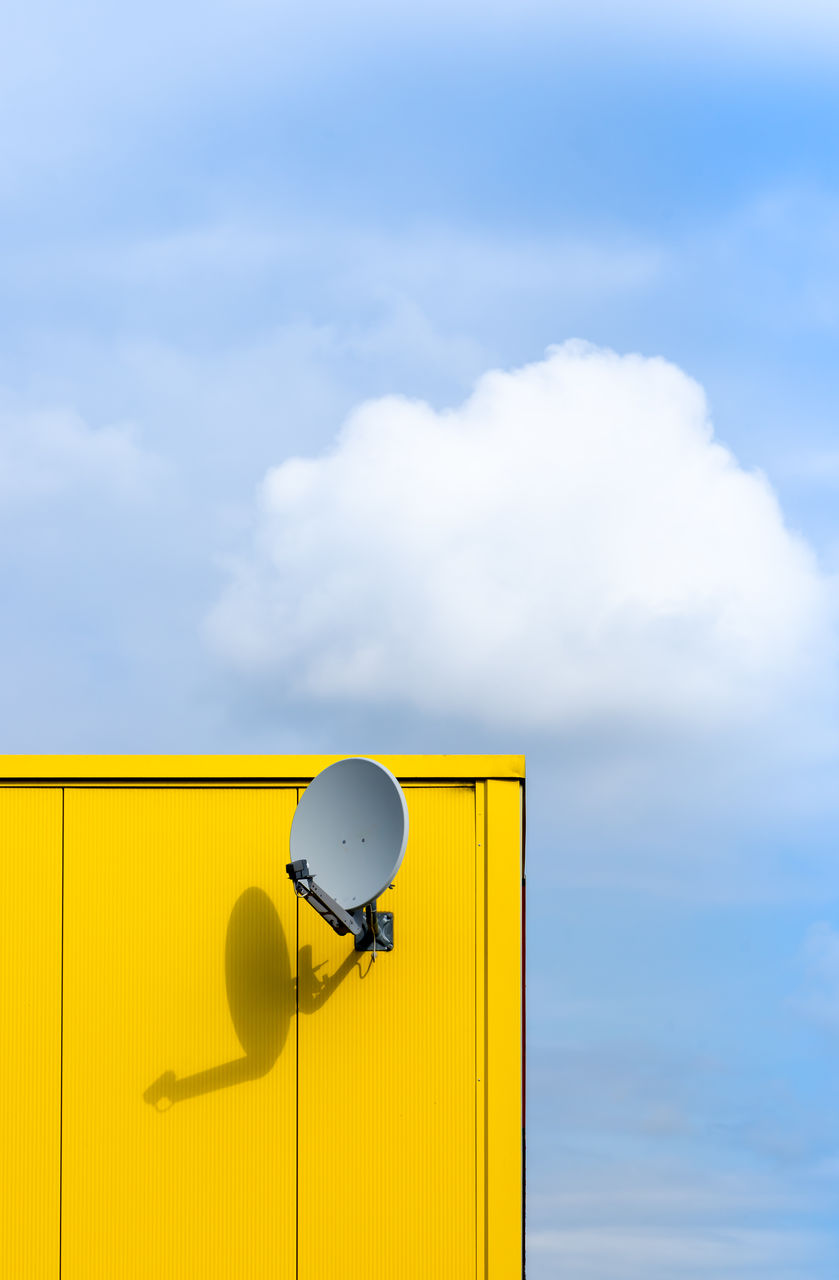 Low angle view of yellow satellite dish  against sky