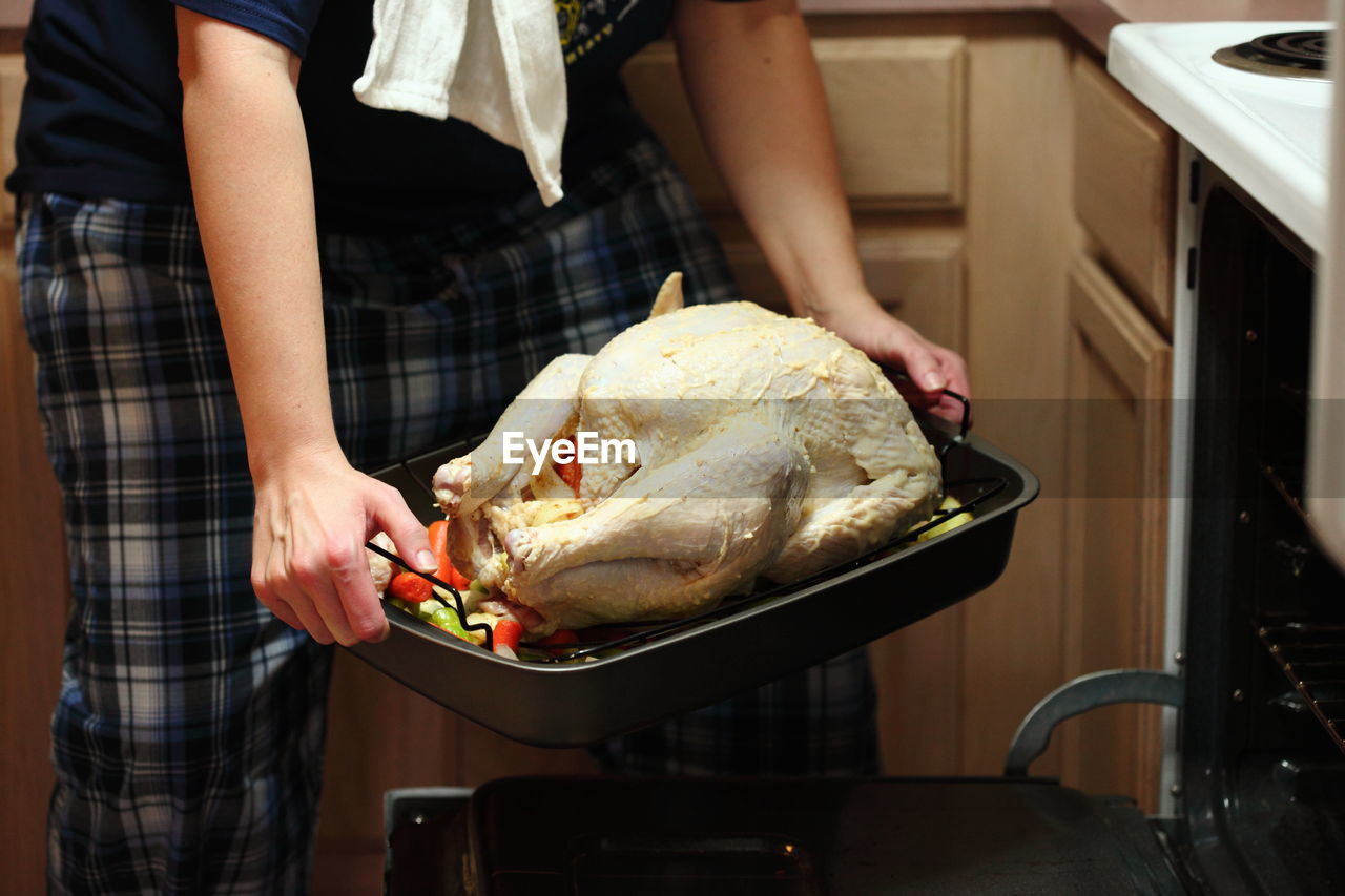 Chef putting chicken dish into oven