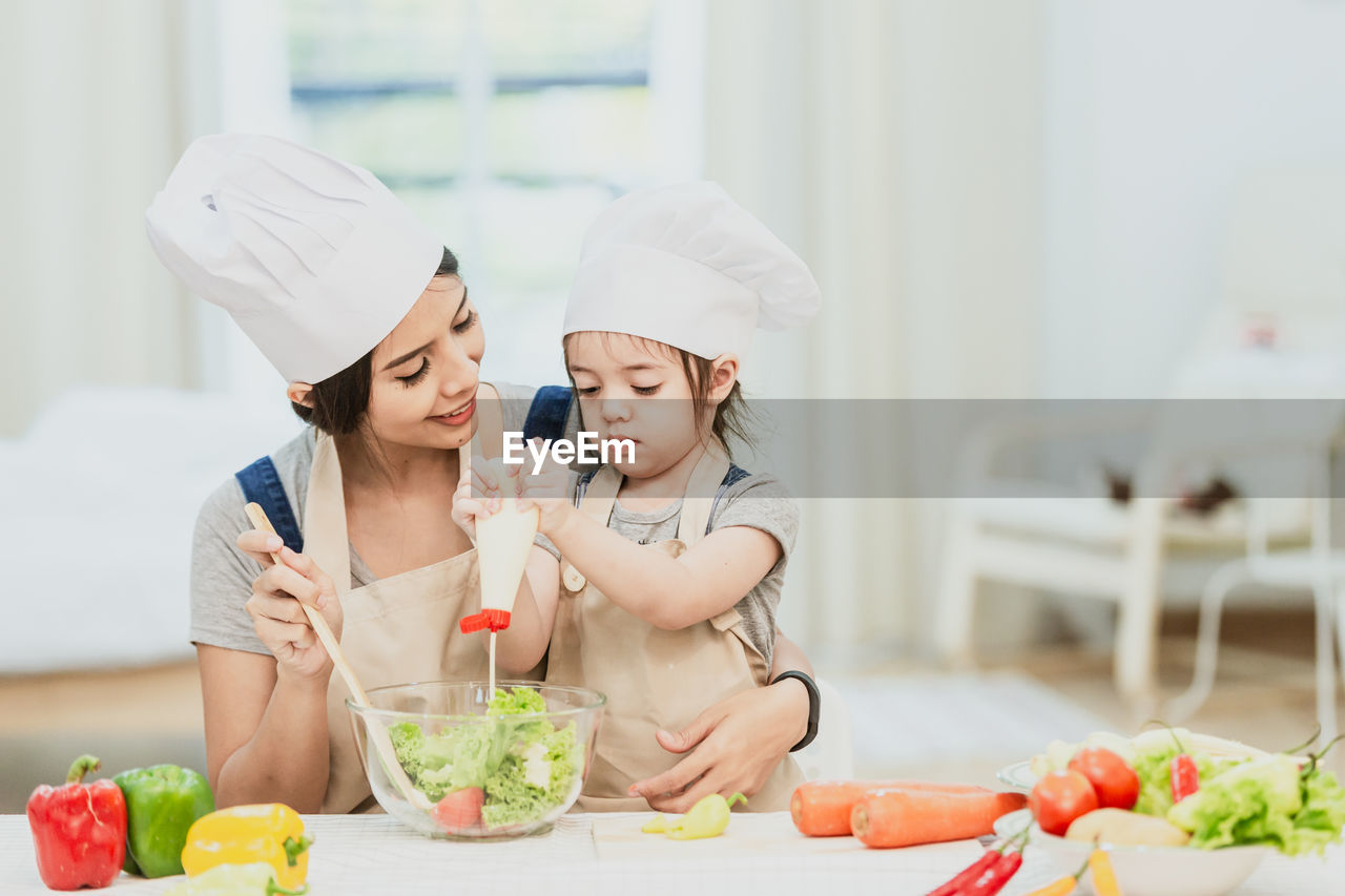 MIDSECTION OF WOMAN HOLDING ICE CREAM CONE