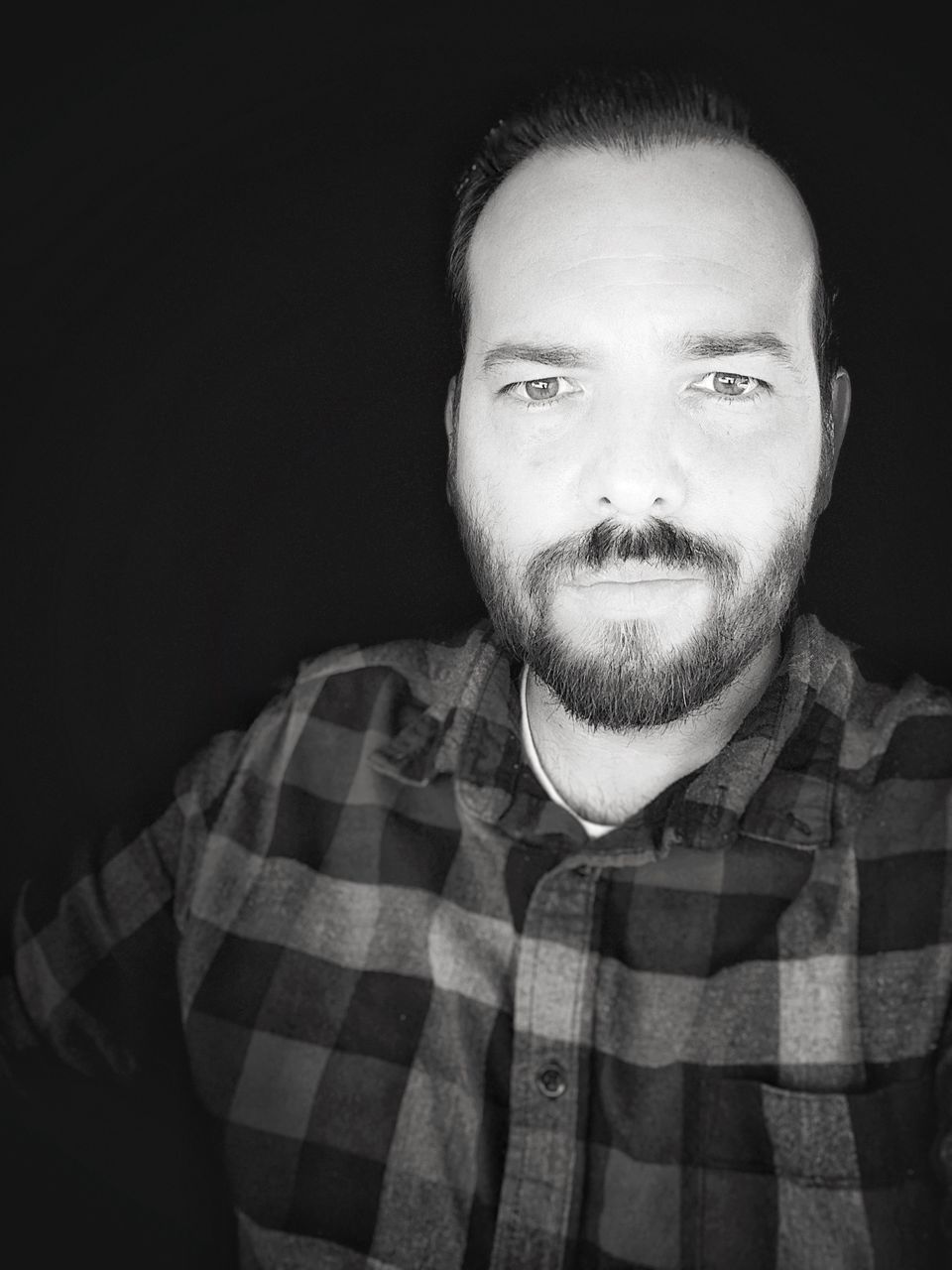 Portrait of man standing against black | ID: 142709039