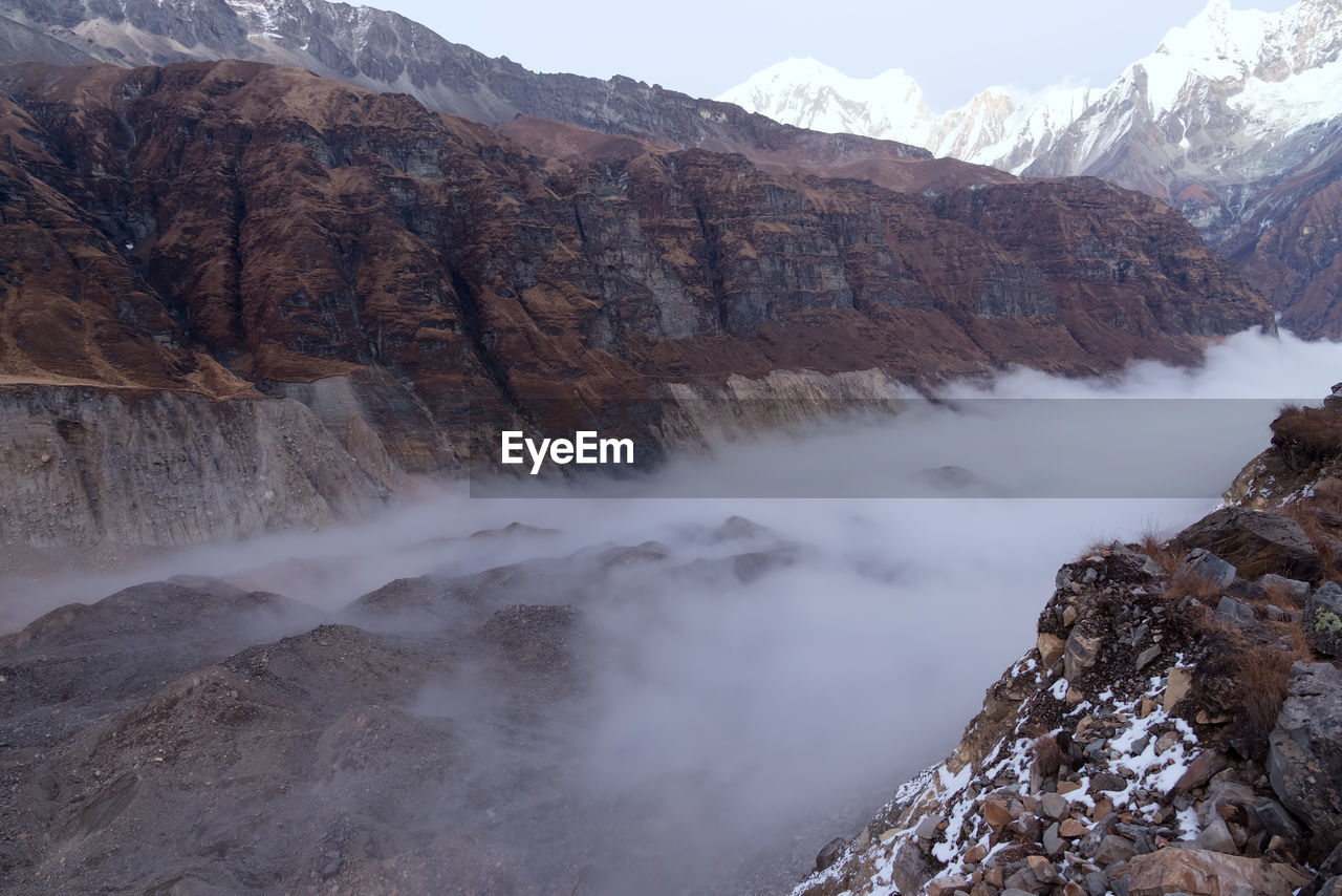 Scenic view of glacier with fog in mountains
