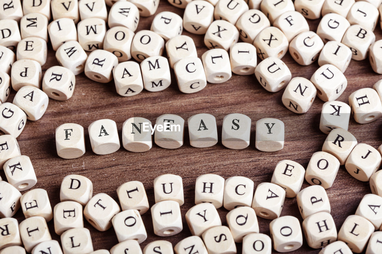 Word fantasy in letters on cube dices on table.