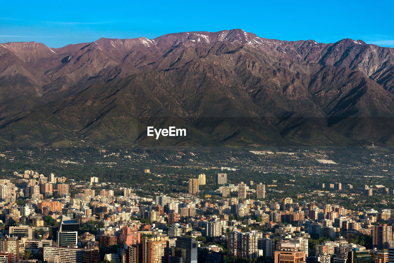 The andes mountain range with buildings of the wealthy district of providencia in santiago de chile.