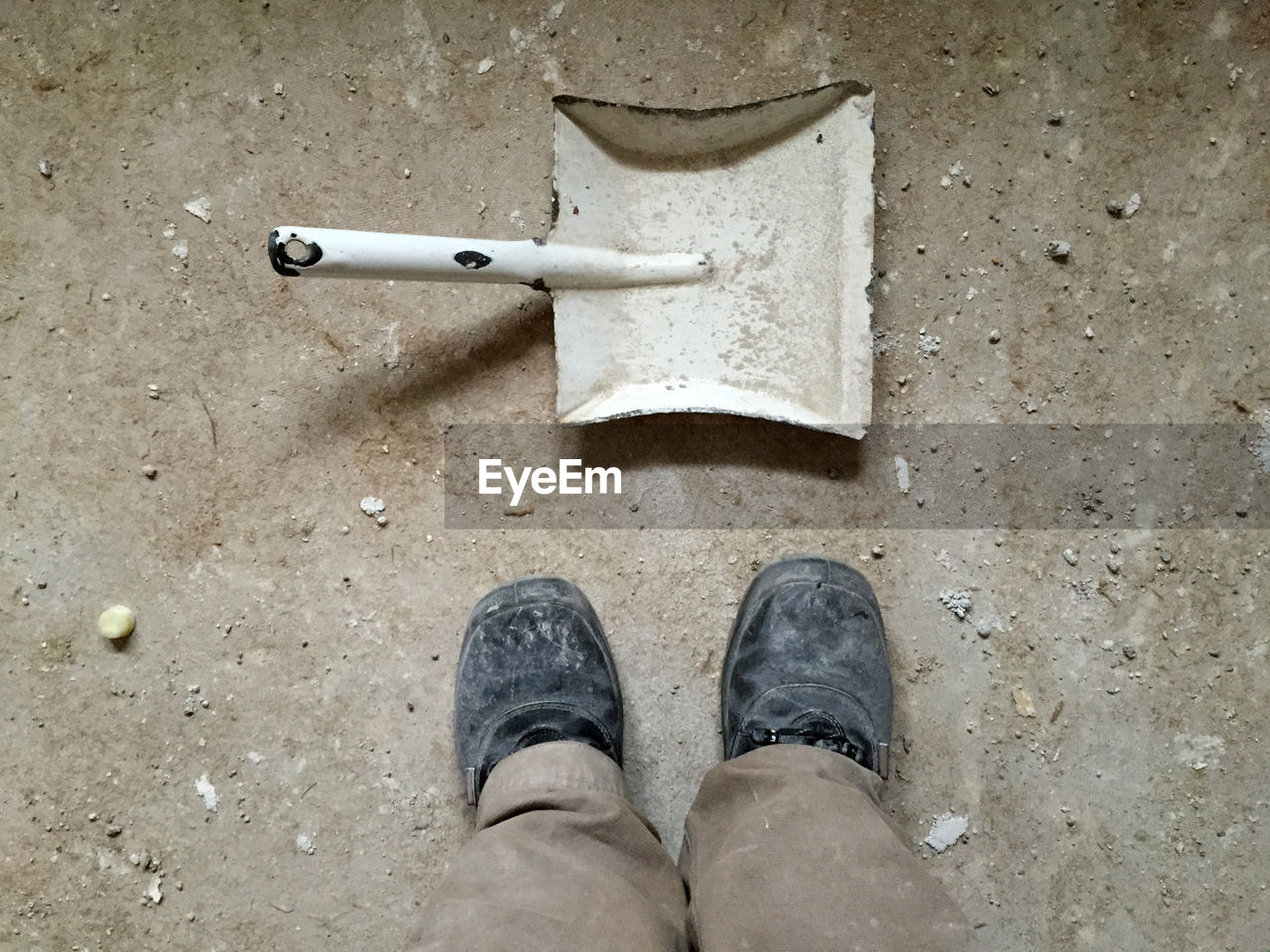 Low section of man standing by work tool on floor