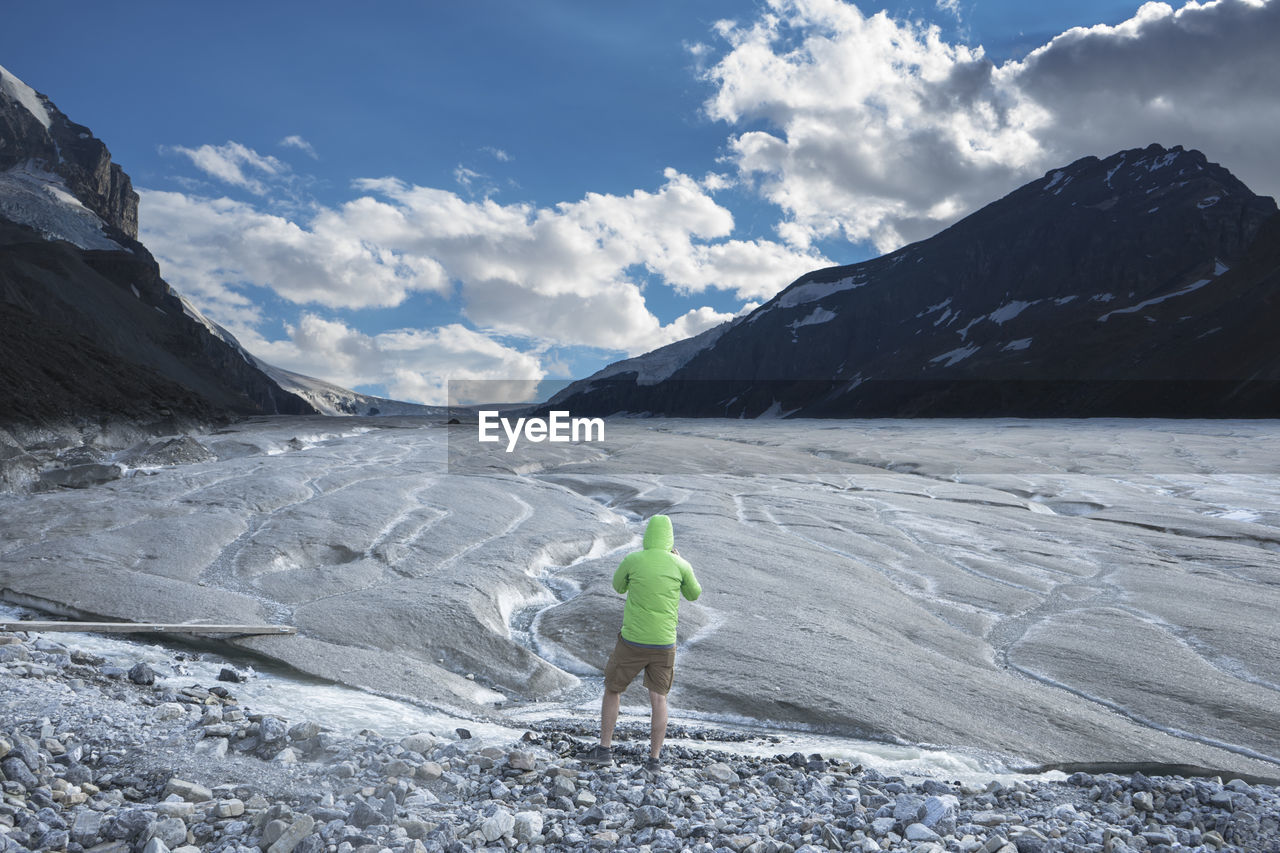 Rear view of person standing against landscape during winter