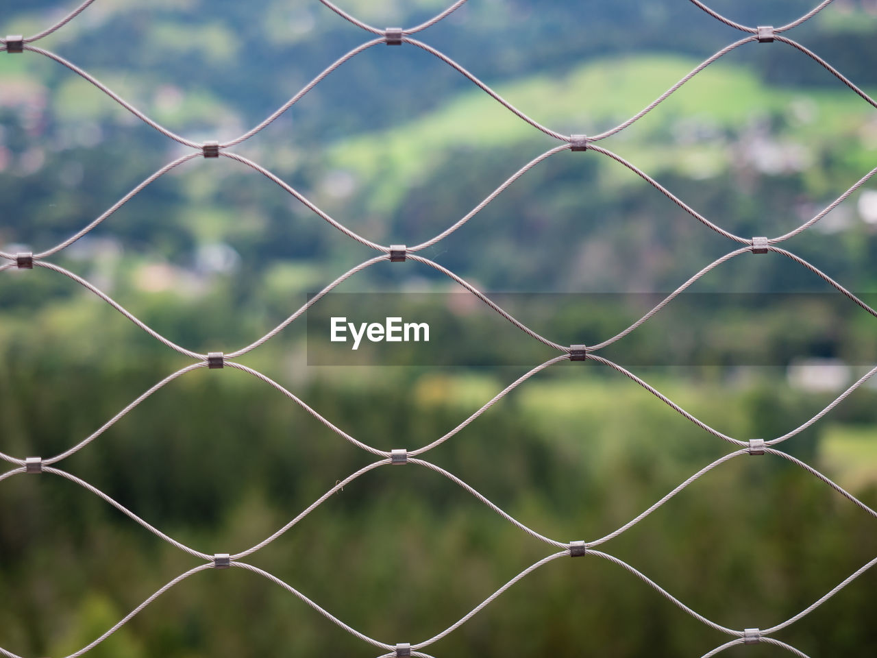 Wire mesh metal against landscape. close up