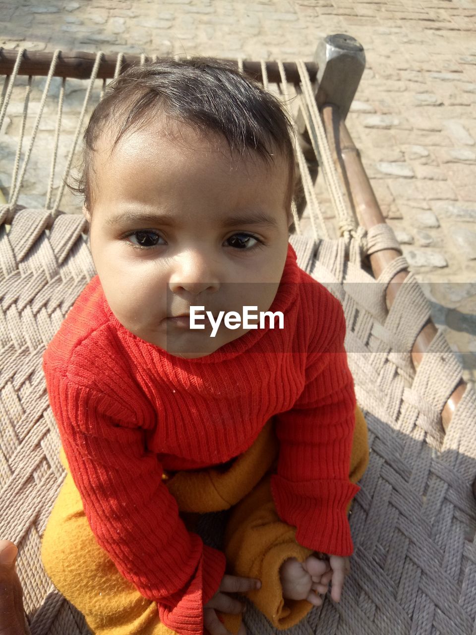 PORTRAIT OF CUTE BABY GIRL SITTING ON FLOOR